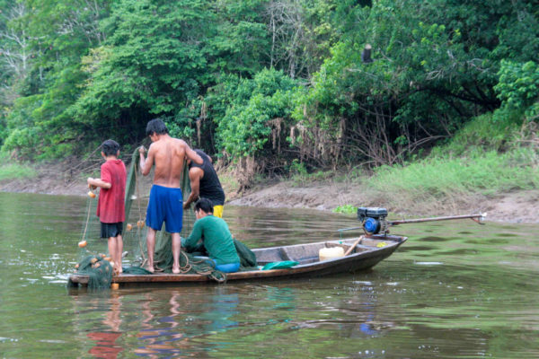 Fischer in einem flachen Boot auf dem Amazonas in Peru