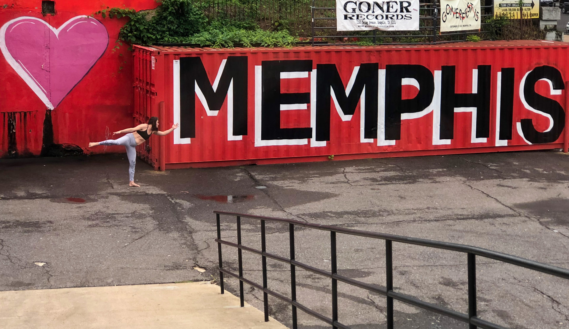 Frau macht Yoga-Übung vor Schiffscontainer mit der Aufschrift Memphis