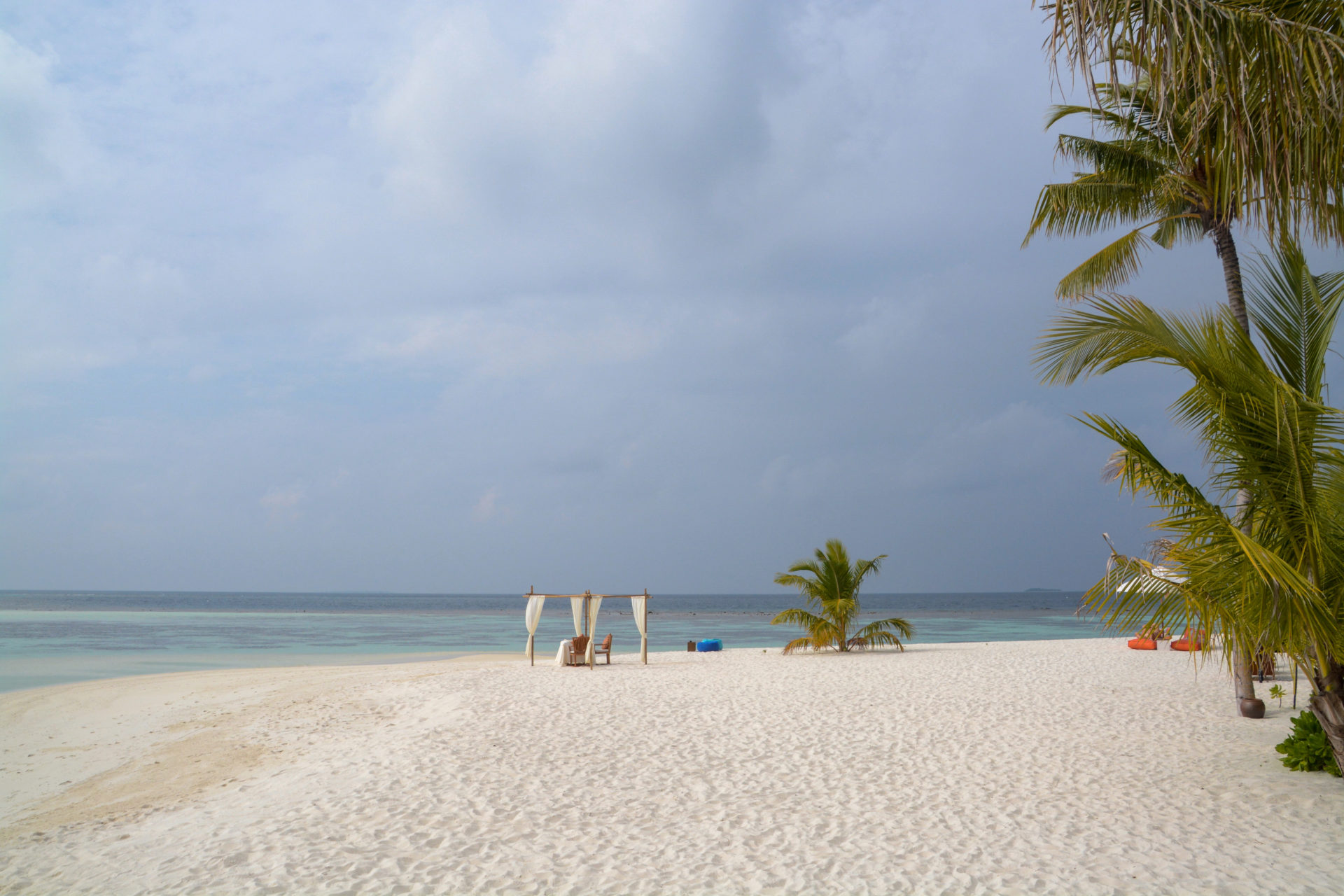 Strand mit Himmelbett und Palem nauf Mirihi Island auf den Malediven