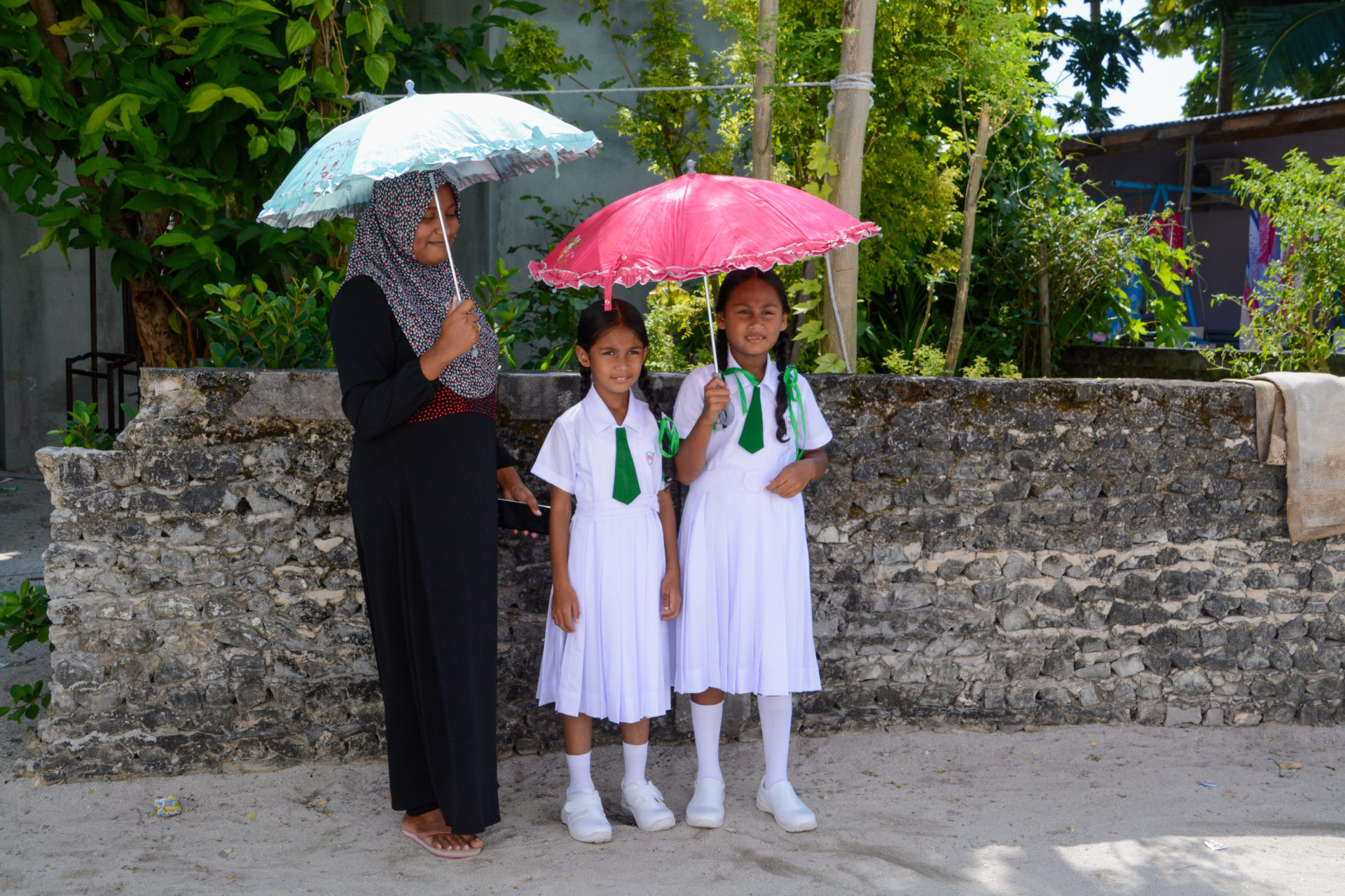 Muslimische Mädchen mit Mutter mit Sonnenschirmen auf Fenfushee Island