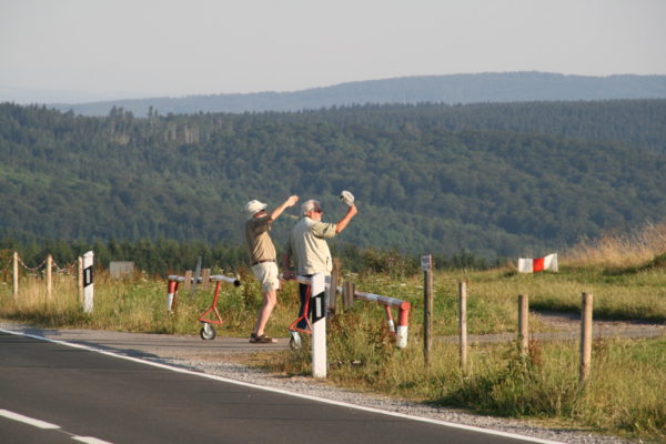 Zwei Männer beobachten an der Rhön den Flugverkehr im Gegenlicht