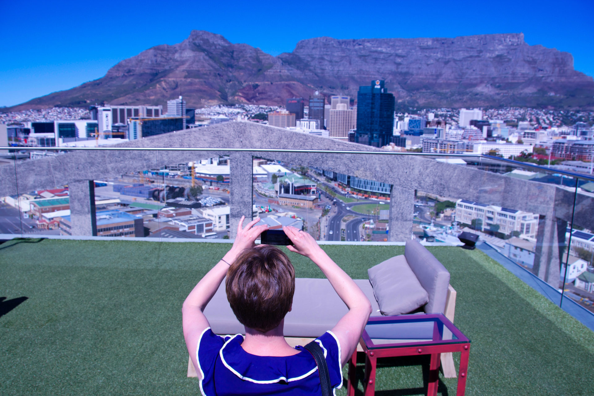 Frau auf Terrasse des Hotel The Silo macht Foto vom Tafelberg
