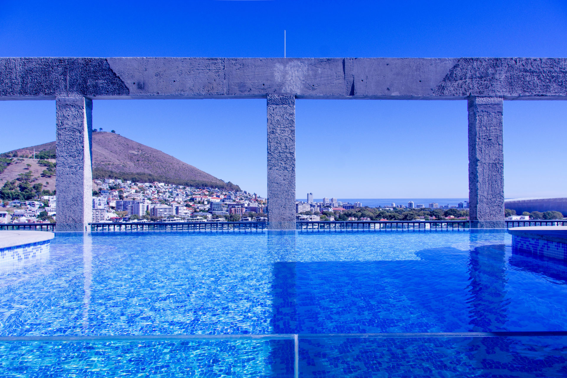 Infinity Pool mit Betonkonstruktion und Blick auf den Lions Head in Kapstadt
