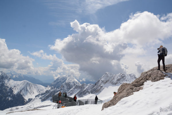 Mann mit Kamera lichtet die Bergwelt der Zugspitze in Richtung Österreich ab