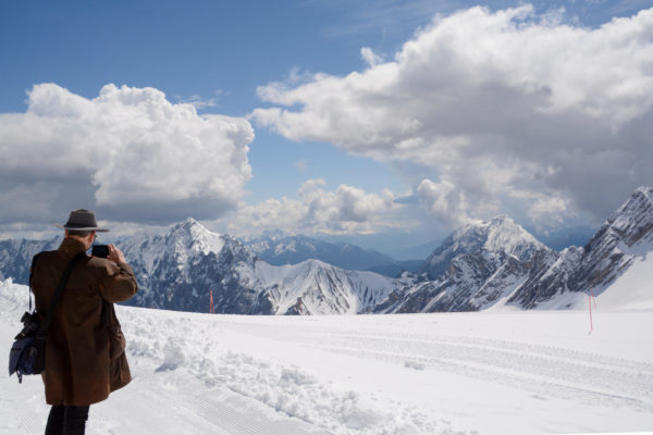 Mann mit Mantel und Hut im Schnee auf dem Gletscher der Zugspitze