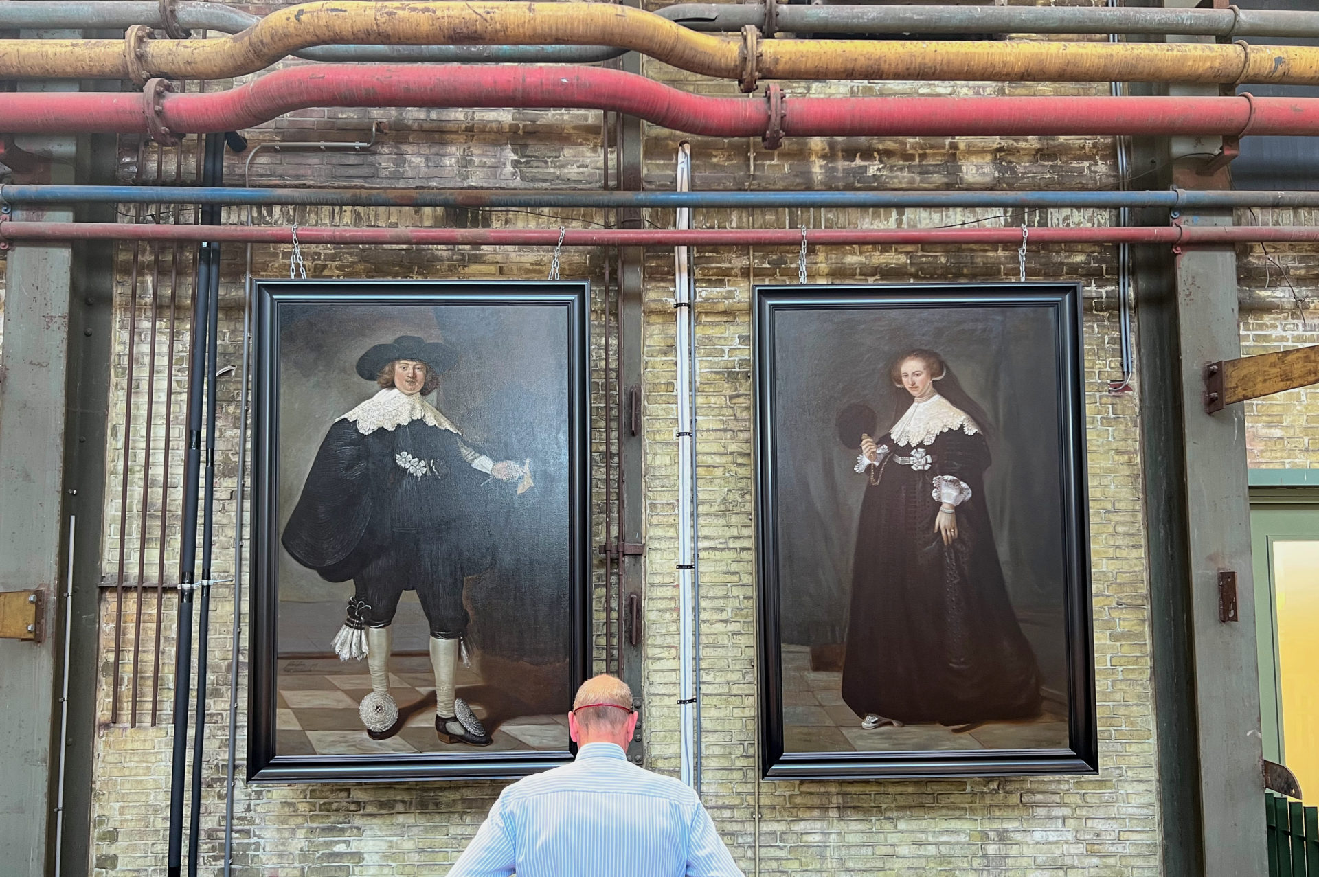 Mann vor zwei imitierten Rembrandts im Street Art Museum in Amsterdam