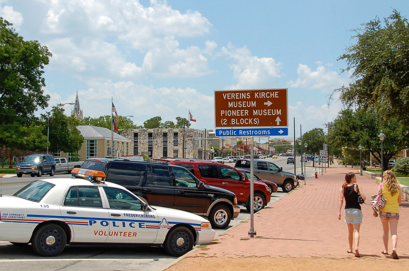 Straßenbild in Fredericksburg, Texas, mit Schild zur Vereinskirche und Polizeiwagen