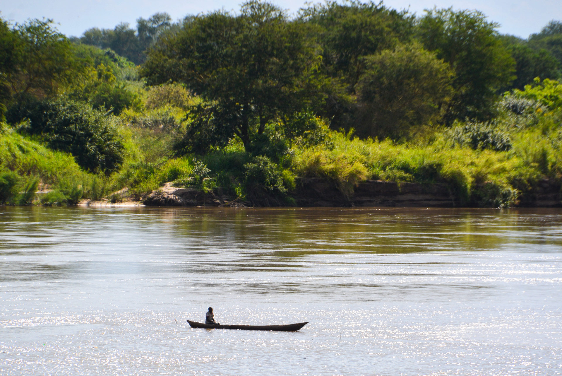 Mann in ausgehöhltem Baumstamm auf dem Fluss Rufiji in Tansania
