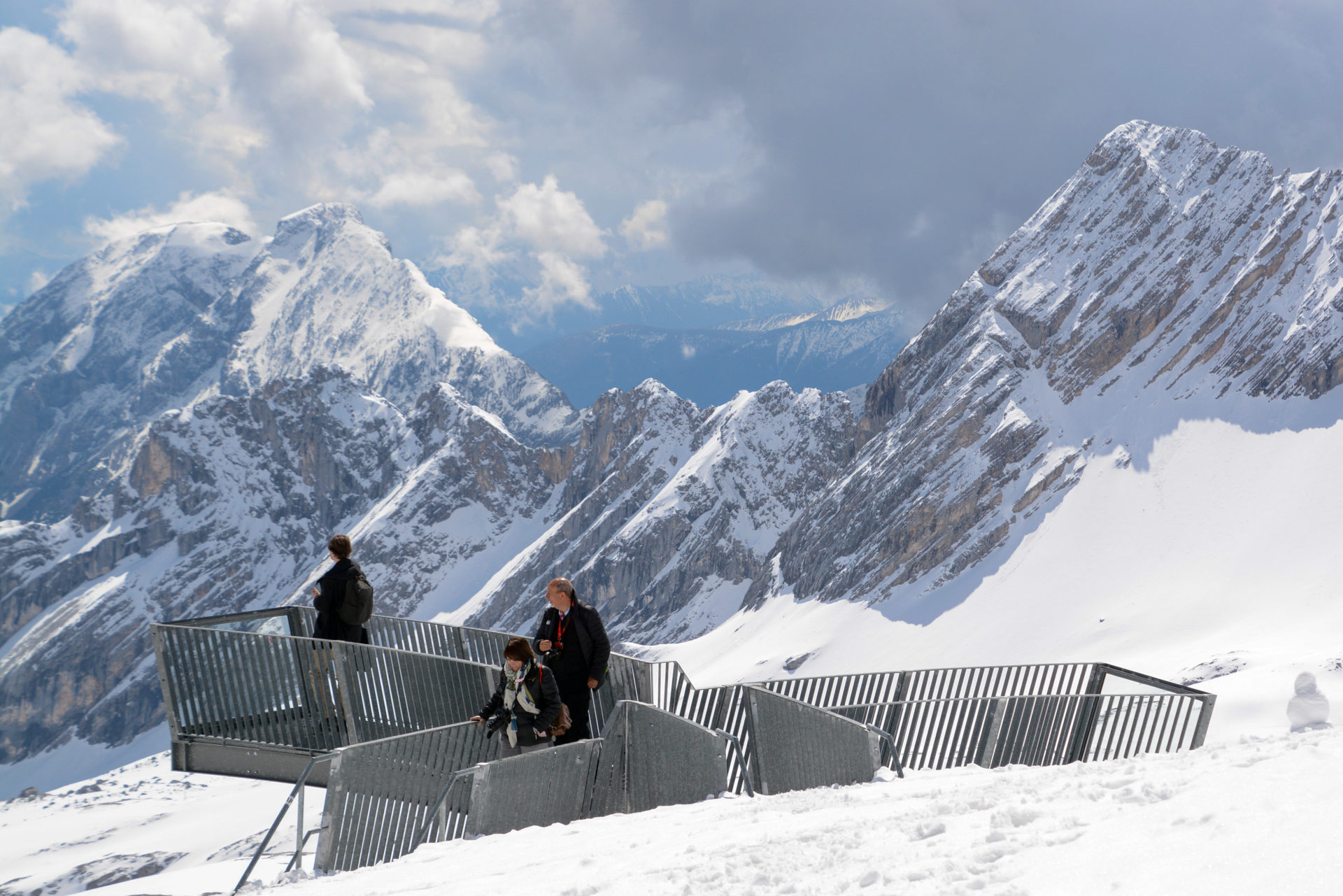 Touristen auf einer Aussichtsplattform der Zugspitze genießen den Fernblick