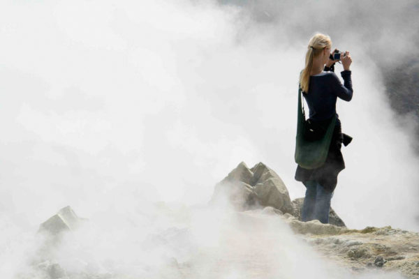 Touristin fotografiert den Nebel vom Rande des Vulcano in den Liparischen Inseln