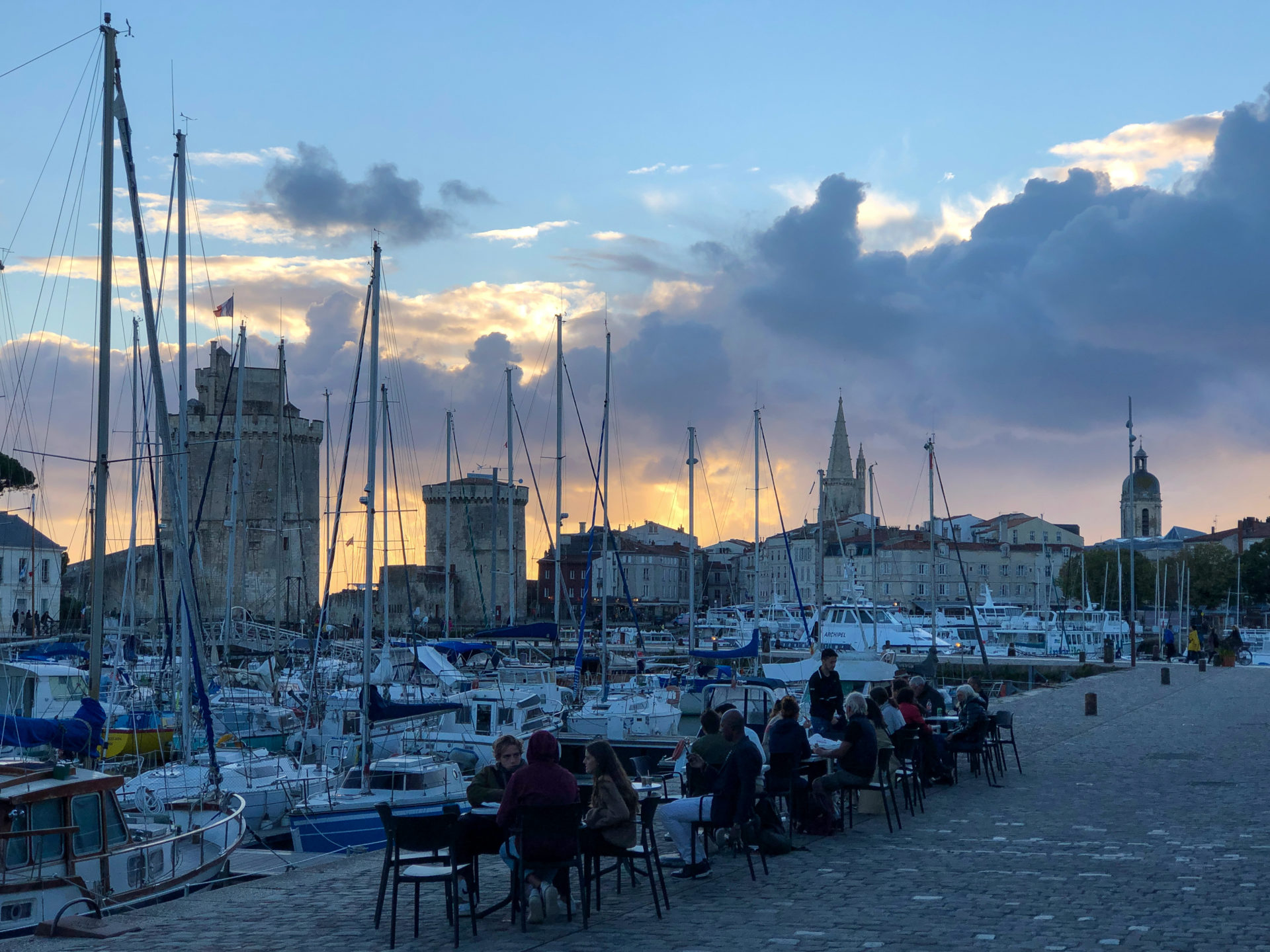 Sonnenuntergang über dem Hafen von La Rochelle mit Turm und Segelbooten