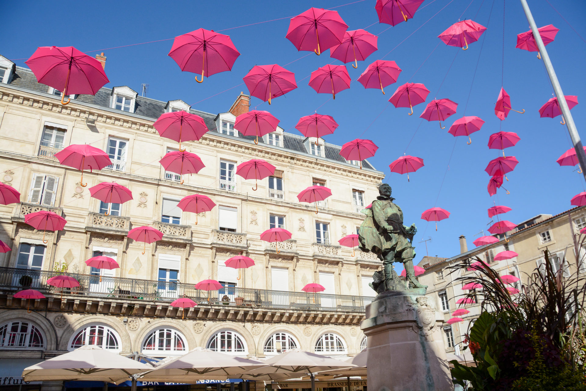 Rote Regenschirm hängen am Himmel von La Rochelle anlässlich des Kampfes gegen Brustkrebs