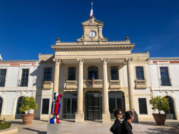 Rathaus von Arcachon mit Passanten vor strahlend blauem Himmel der französischen Atlantikküste