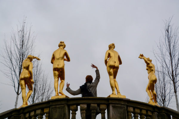 Goldene Statuen in den Herrenhäuser Gärten mit posierender Frau