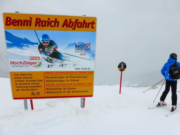 Schild zur Benni-Raich-Abfahrt im Pitztal mit Skiläufer und Hinweis auf schwarze Piste
