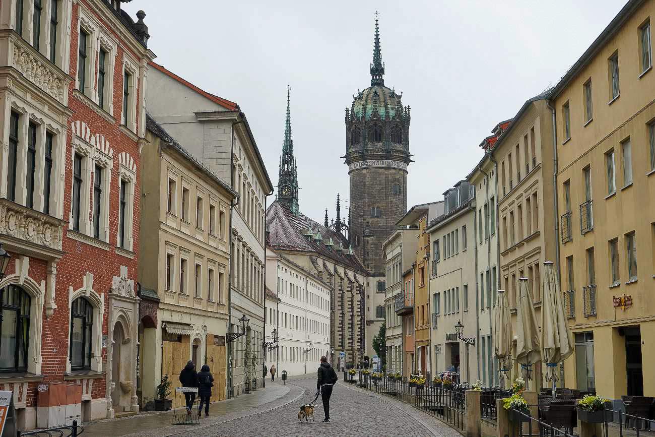 Blick durch eine Straße in Wittenberg mit der Schlosskirche im Hintergrund
