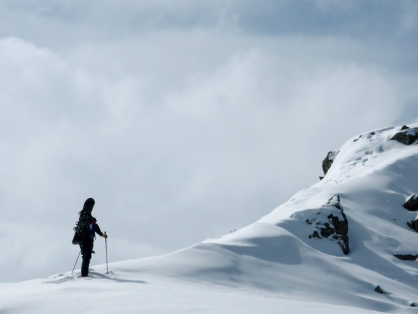 Einsamer Wanderer auf Berggrat im Pitztal mit Snowboard auf dem Rücken