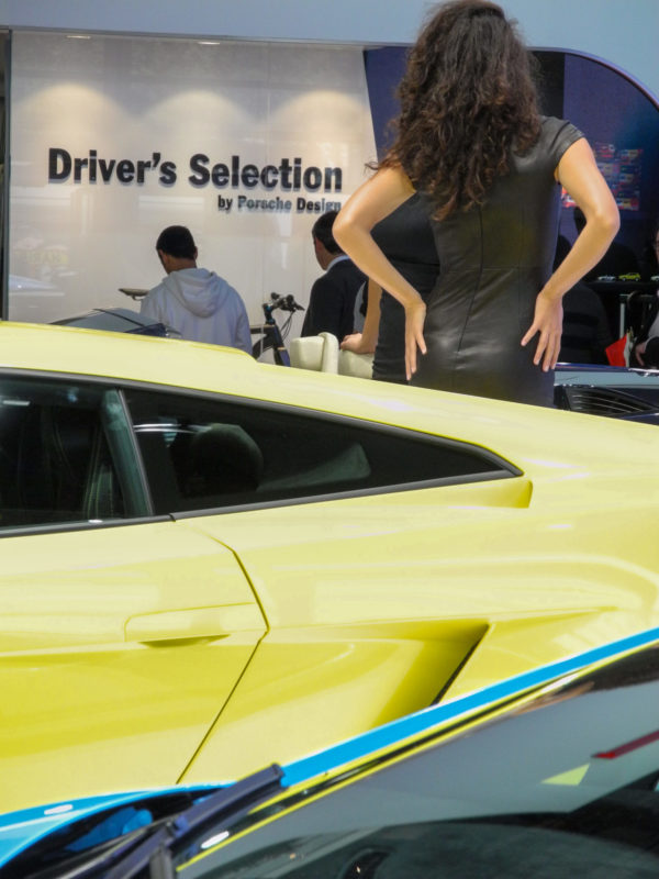 Frau in Lederkleid posiert vor einem Lamborghini