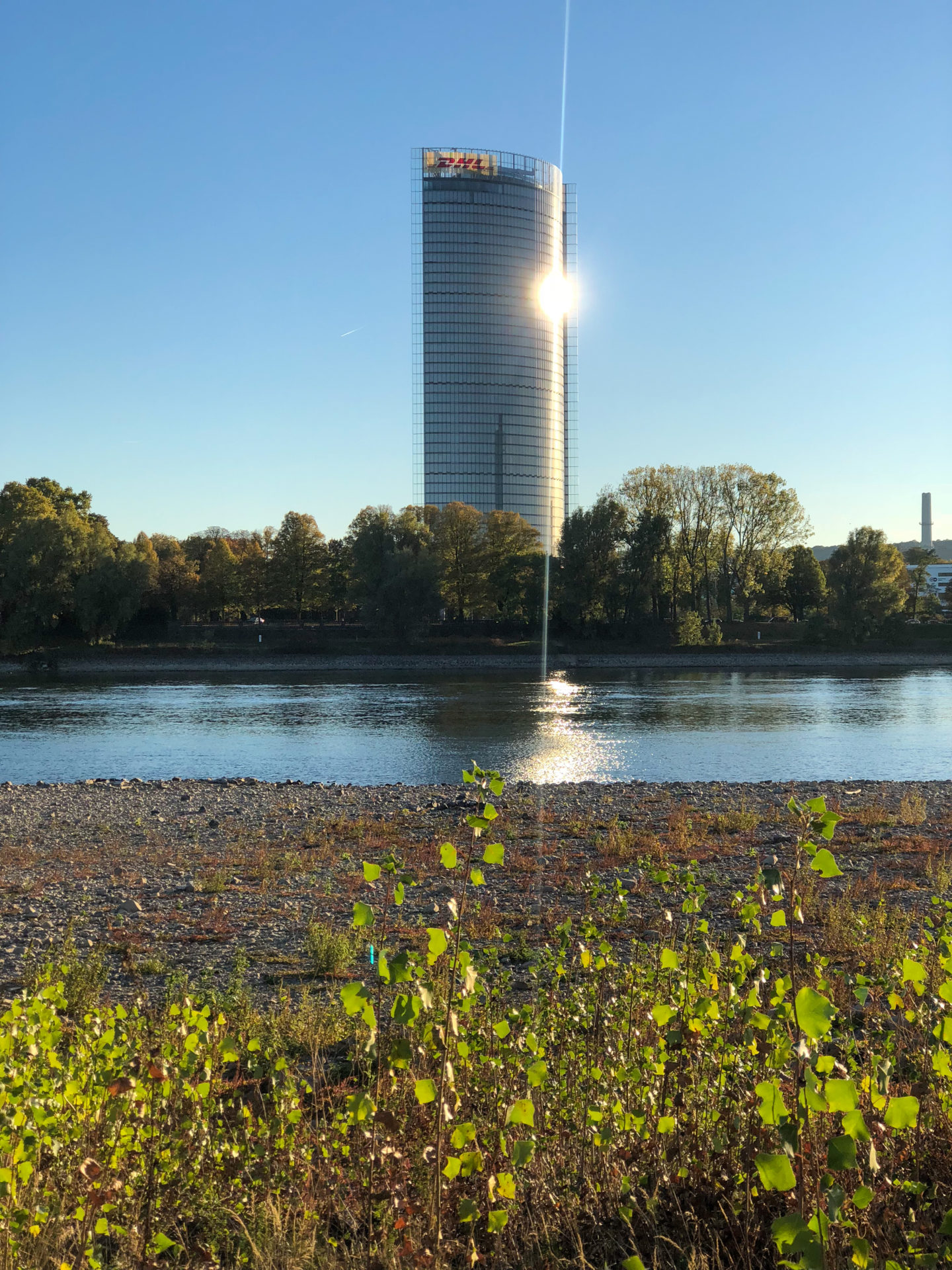 Post-Tower in Bonn mit Rhein und Spiegelbild der Sonne