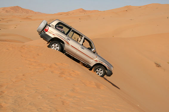 Geländewagen bei der Abfahrt von einer Düne in der größten Sandwüste der Welt