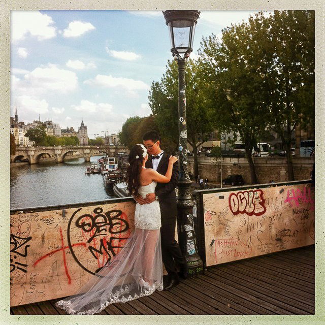 Verliebtes Paar in Hochzeitskleidung auf einer Brücke in Paris