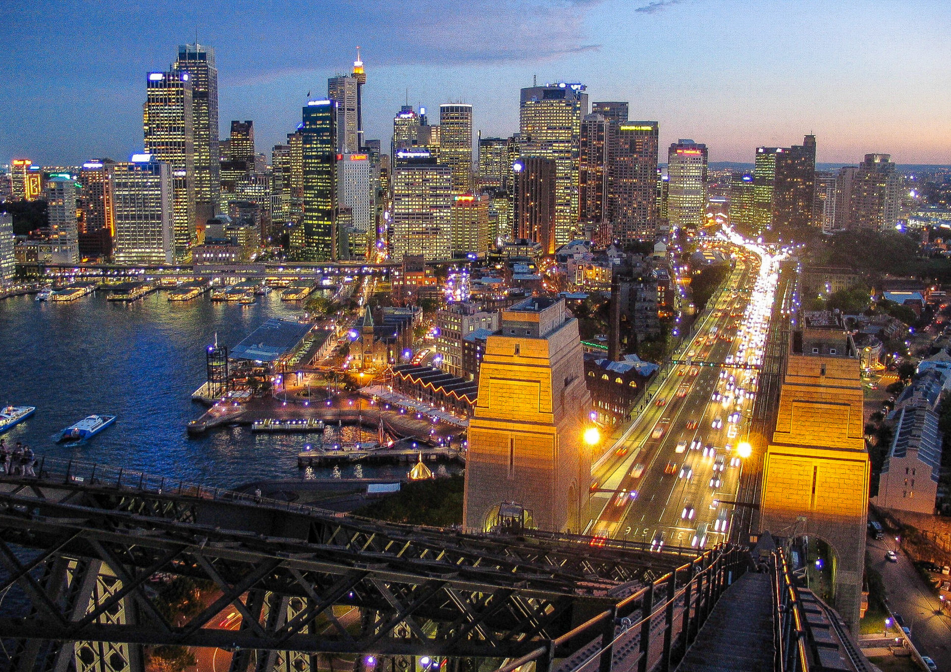 Blick auf die abendlich erleuchtete Skyline von der Harbour Bridge in Sydney