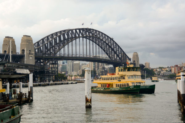 Fähre vor der Harbour Bridge in Sydney an einem wolkigen Tag