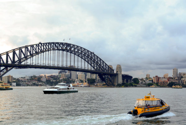 Wassertaxi und Fähre vor der Harbour Bridge in Sydney, auf der immer das erste Neujahrsfeuerwerk gezündet wird
