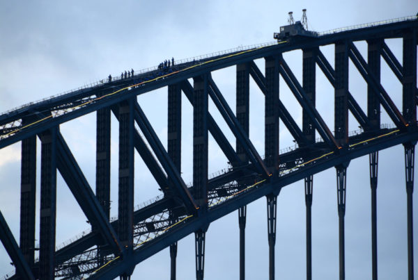Kletterer auf der Hafenbrücke von Sydney mit Kran