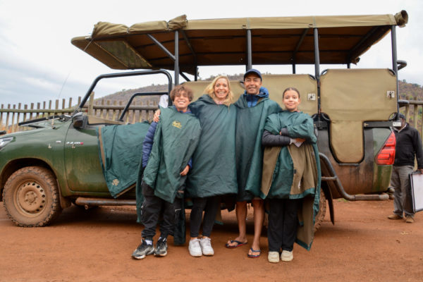 Familie Sebban-Weber aus Berlin vor einem Geländewagen während einer Safari