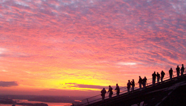 Abenteuerlustige Kletterer auf der Sydney Harbour Bridge während des Sonnenuntergangs