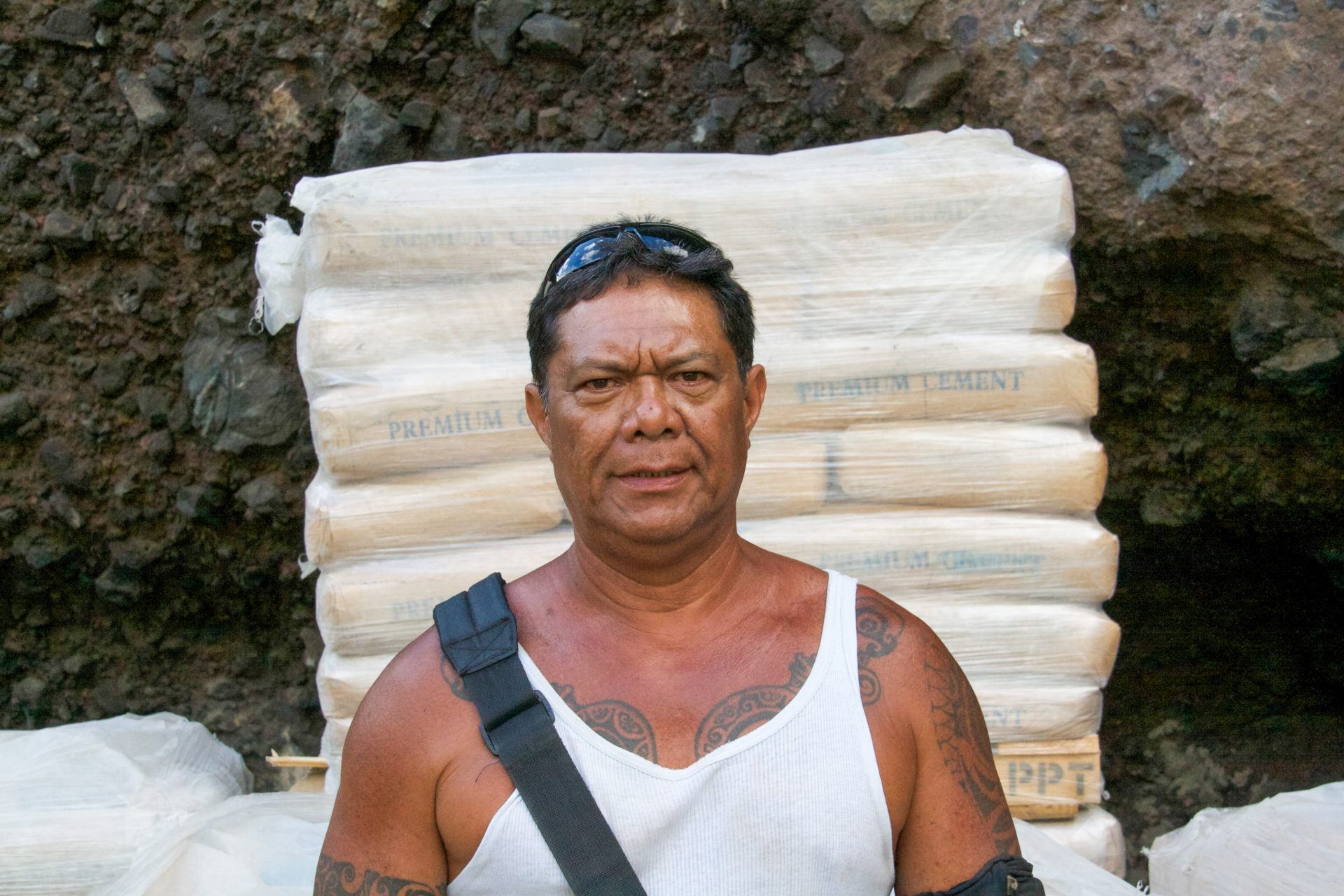 Tätowierter Polynesier vor Zementsäcken, die auf die Aranui 3 geladen werden