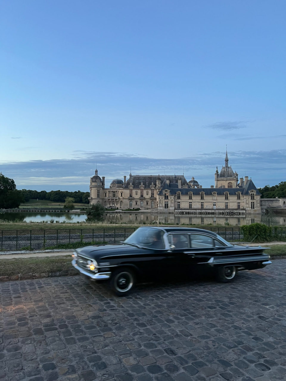 Oldtimer auf Kopfsteinpflaster vor dem Schloss von Chatilly