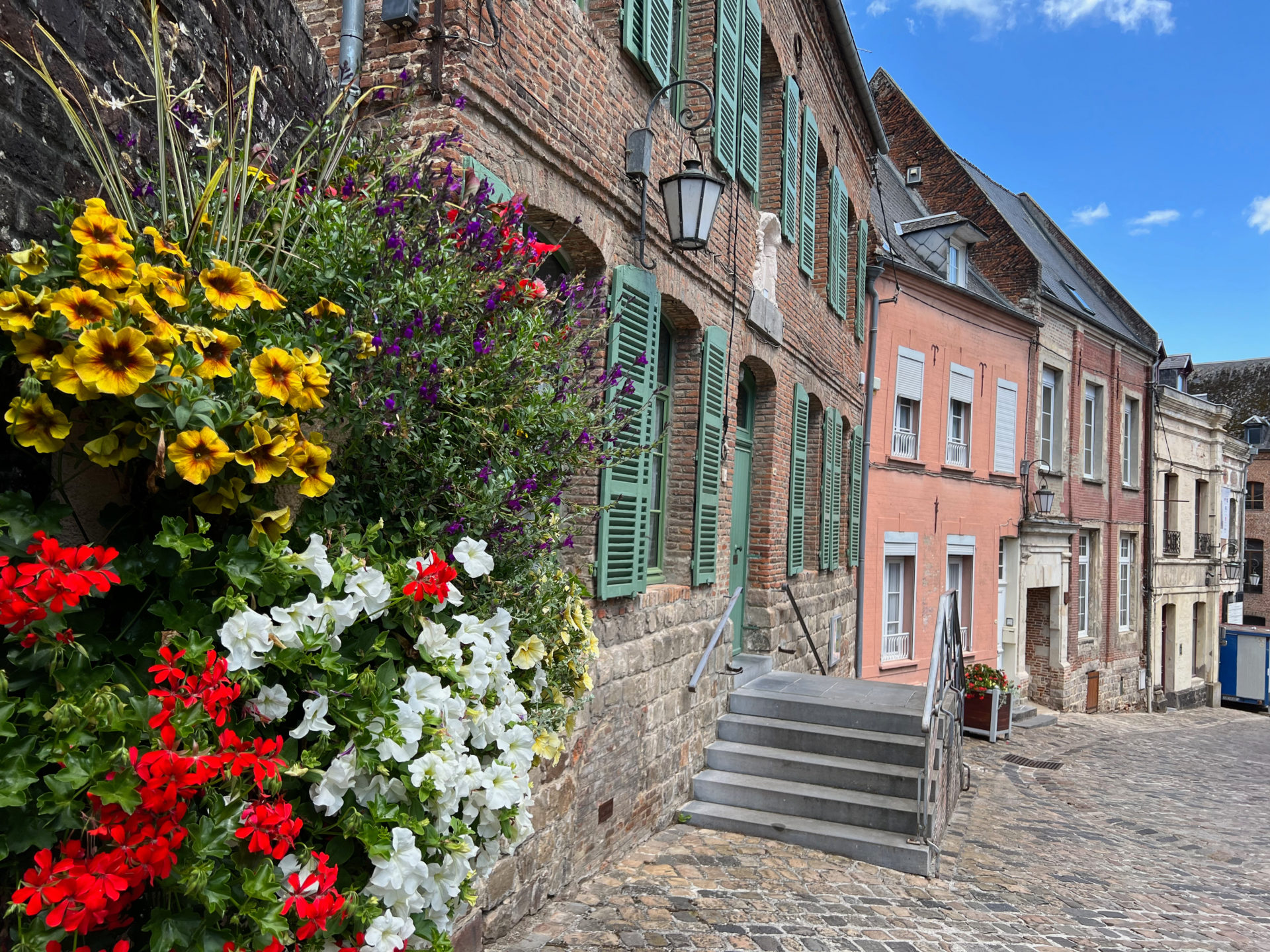Stadtansicht von Guise mit Blumen, Treppe und Kopfsteinpflaster