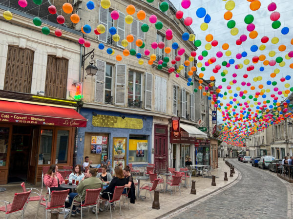 Straßenszene mit Ballons über einer Einkaufsstraße in der Stadt Laon in Frankreich