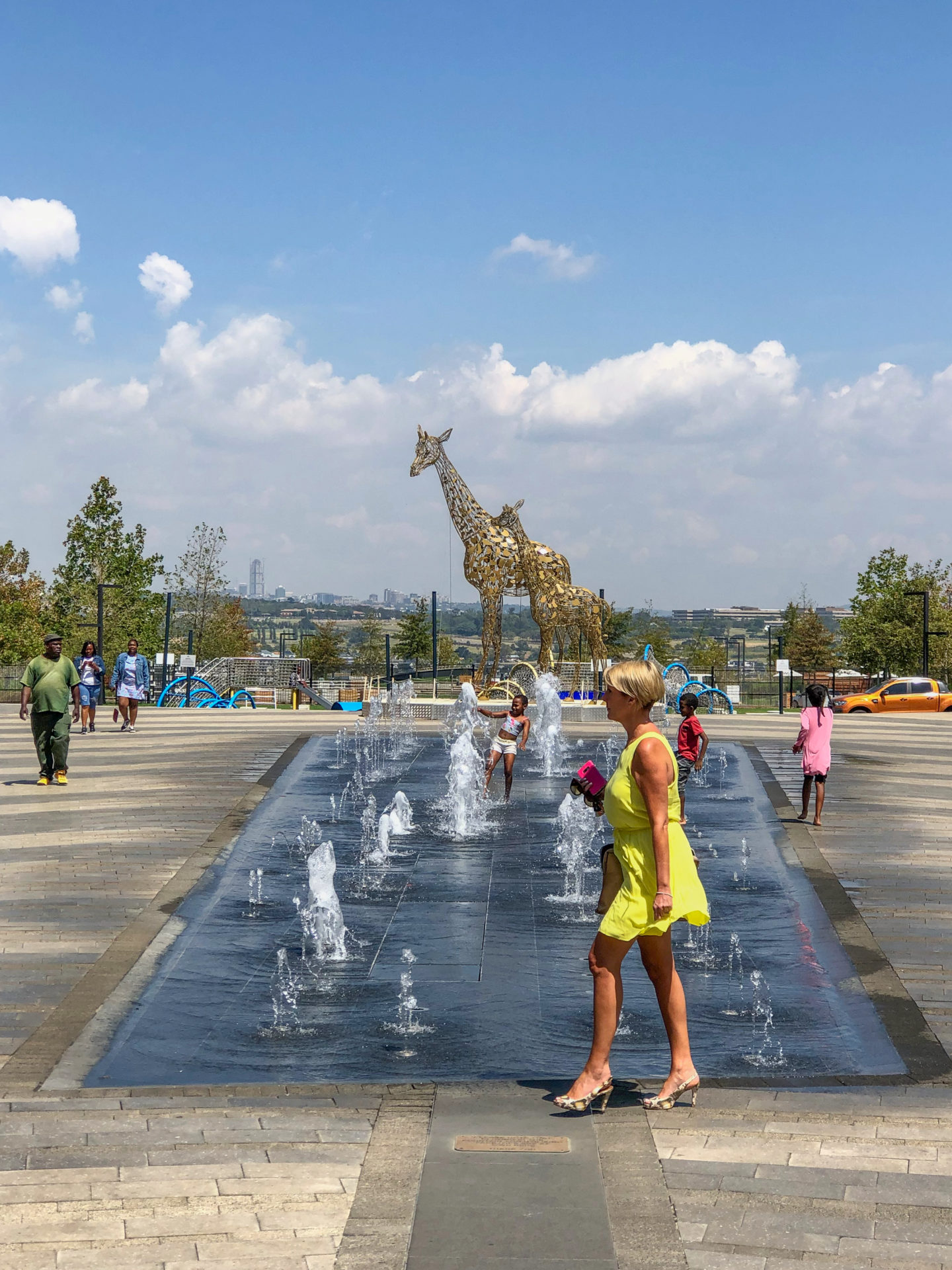 Frau vor Giraffe und Springbrunnen bei der Mall of Africa, einem der besten Tipps für Johannesburg