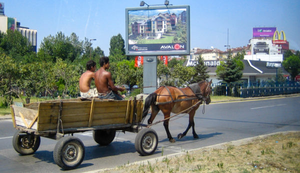 Ein Pferdewagen mit zwei jungen vor Reklameschildern in der bulgarischen Hauptstadt Sofia
