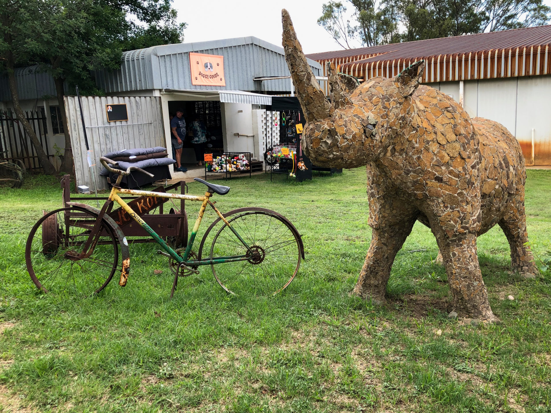 Rostiges Fahrrad und Skulptur eines Nashorns im Riversands Farm Village bei Johannesburg