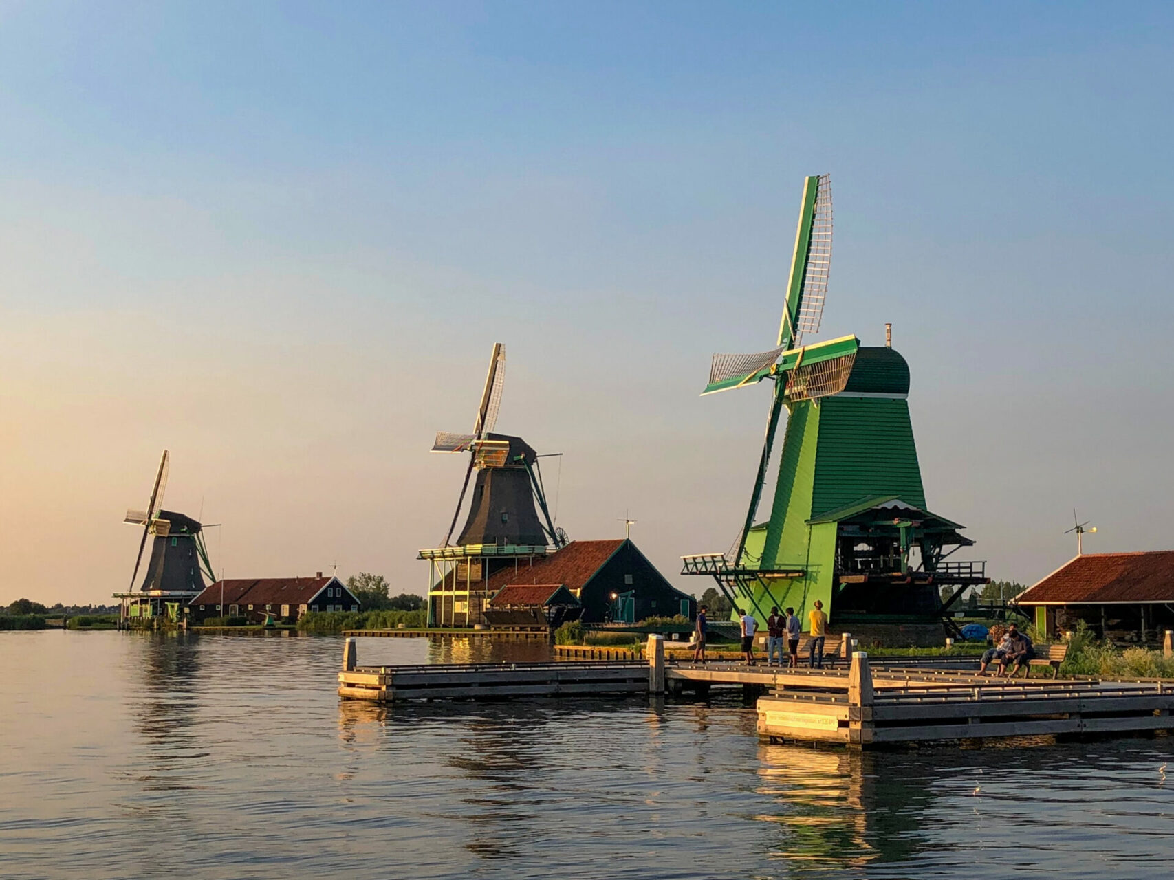 Drei Windmühlen auf der Zaanse Schans im Abendlicht mit viel Wasser