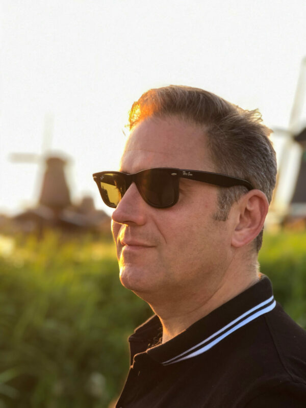 Autor Ralf Johnen im Abendlicht vor den Windmühlen auf der Zaanse Schans