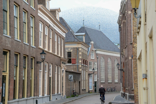 Radfahrer in der Koestraat in Zwolle mit dem Dach des Museums De Fundatie im Hintergrund
