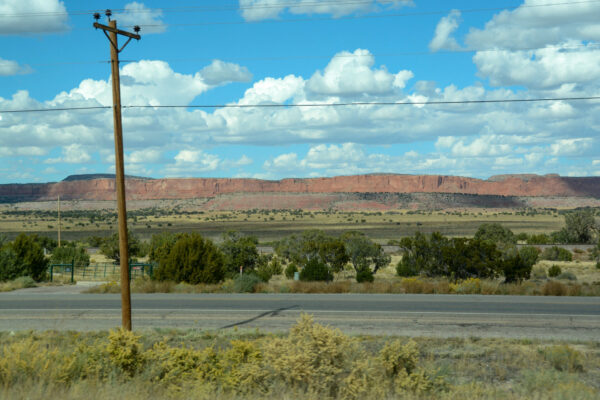 Historische Trasse der Route 66 in New Mexico mit Steinformationen und stahlblauem Himmel