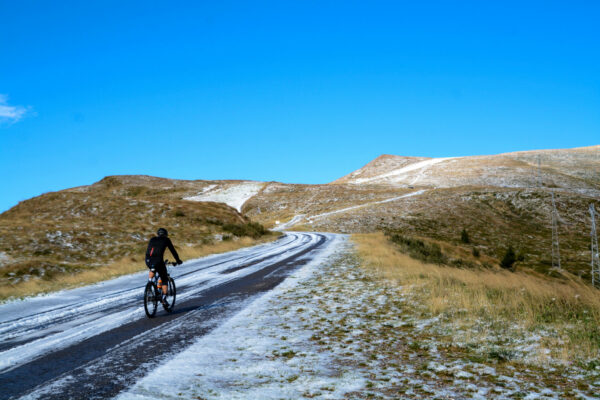 Einsamer Radfahrer auf einer schneebedeckten Straße in der Lombardei