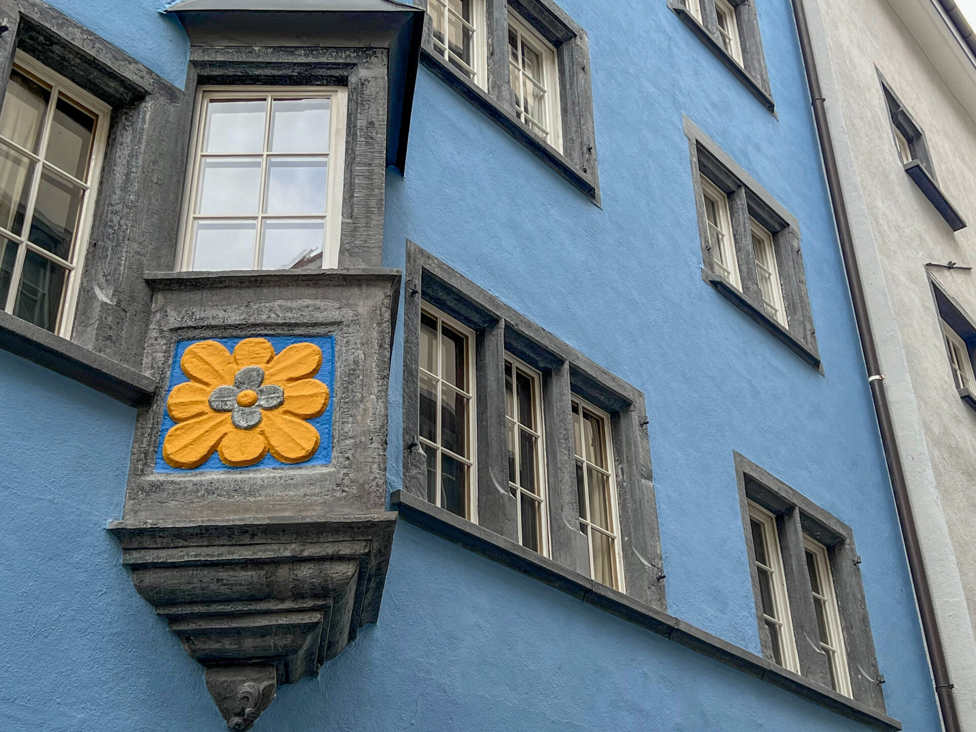 Erker mit Blume an einer Hauswand in der Altstadt von Chur