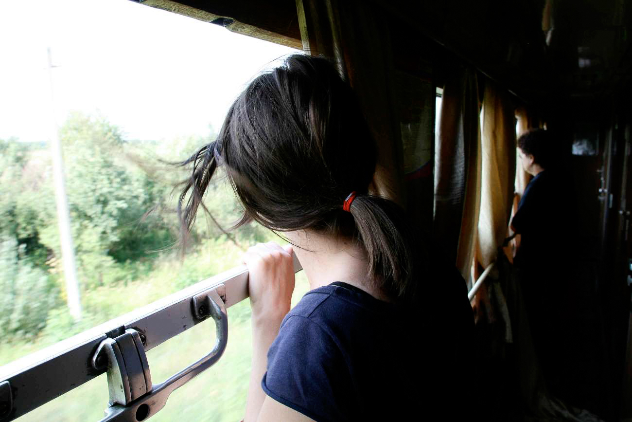 Ein Frau blickt aus dem Fenster des Zugs von Berlin auf die Krim