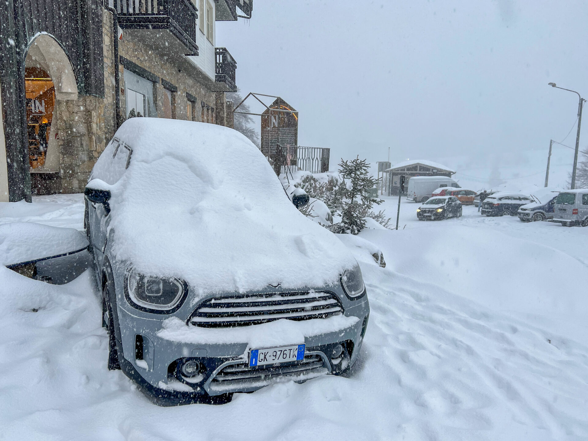 Voll verschneites Auto in einem Skigebiet im Piemont