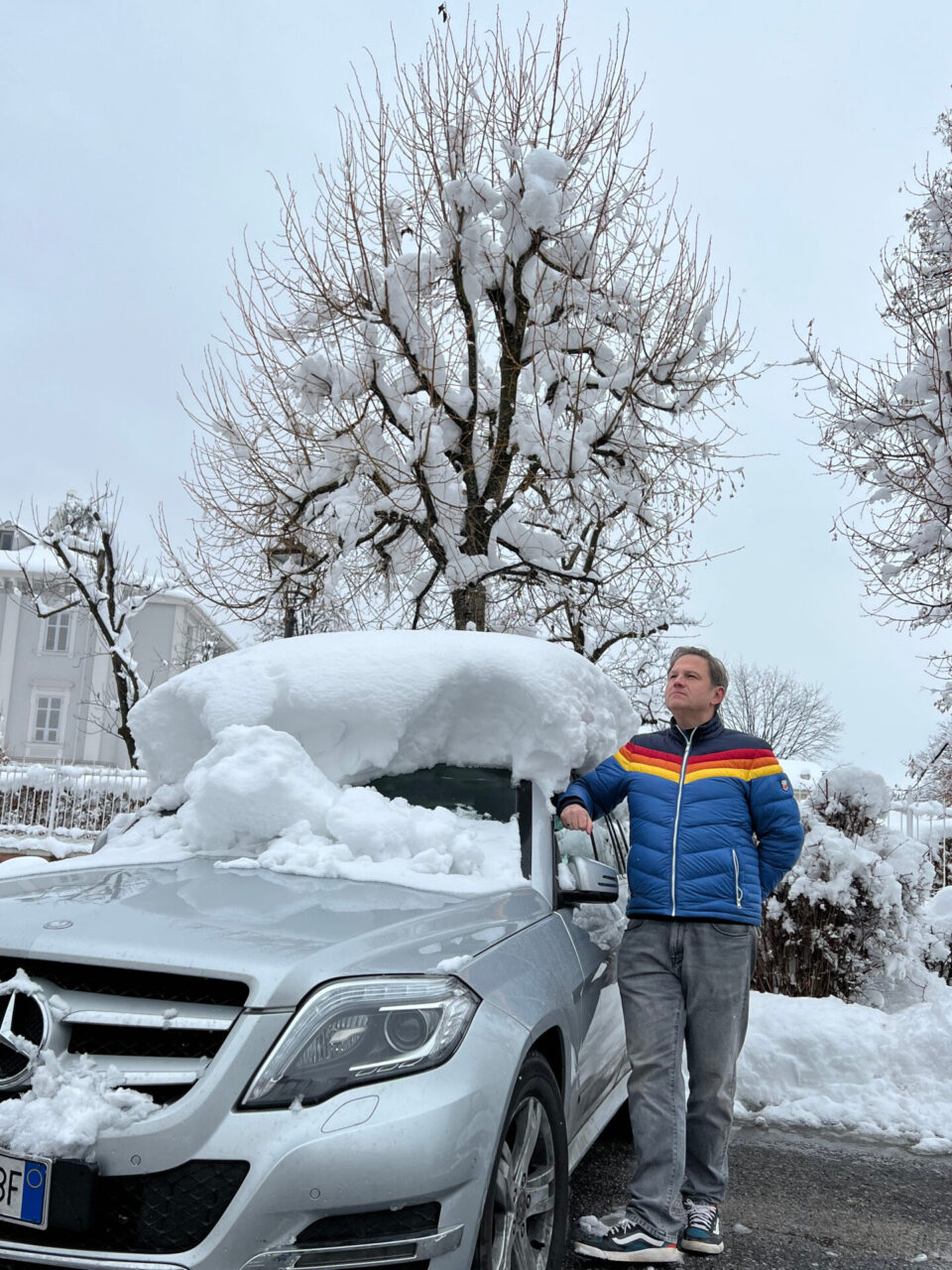 Autor Ralf neben einem Wagen mit einem halben Meter Neuschnee auf dem Dach in Vicoforte im Piemont