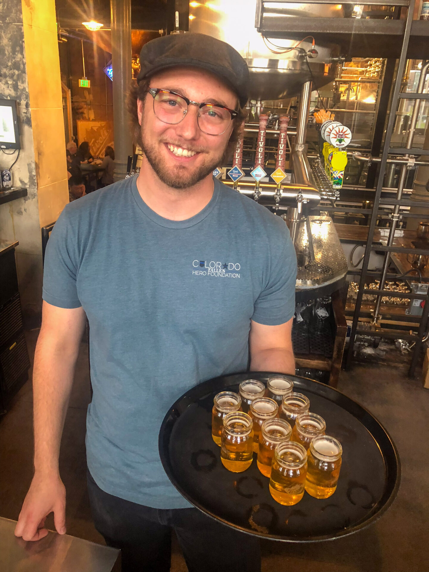 Mann mit Tablett voller Biergläser in einer Brauerei in Denver