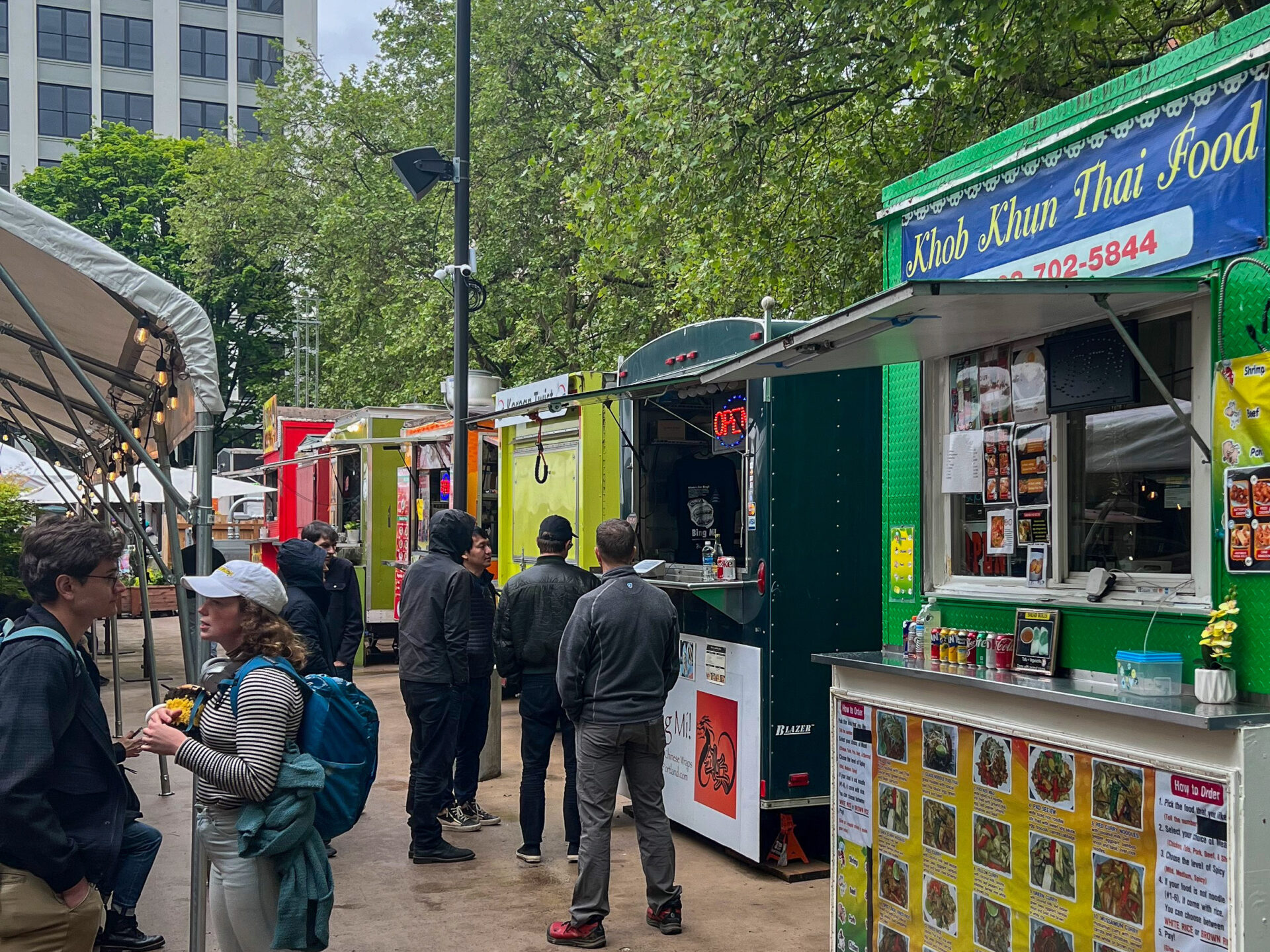 Mehrere Buden für Street Food in Portlands Midtown Beer Garden mit Menschen in der Schlange