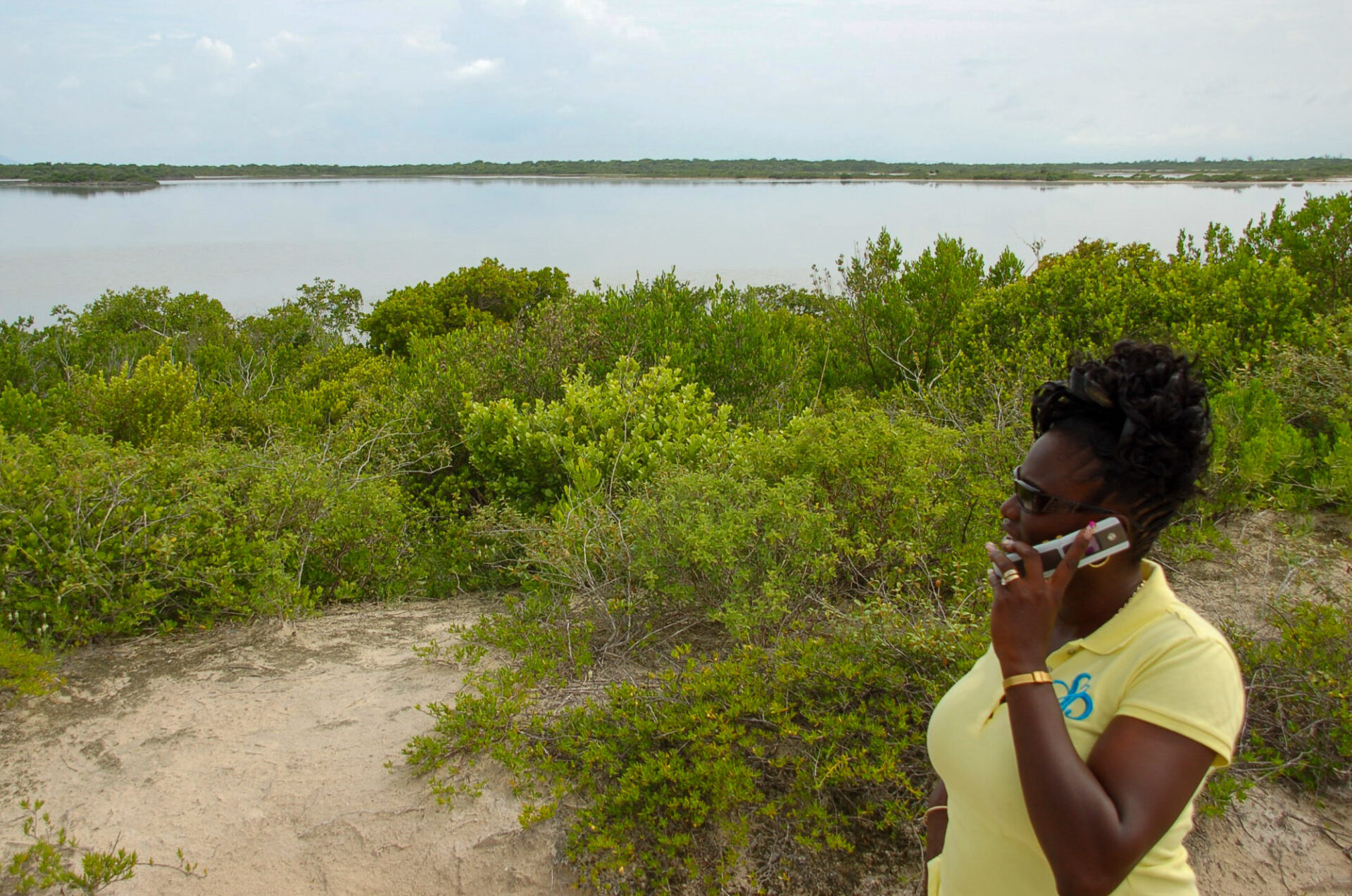 Frau mit Mobiltelefon an einem See auf den British Virgin Islands